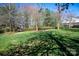 Green backyard with trees, a manicured lawn, and a bench surrounded by lush landscaping at 875 Stratford Run Dr, Fort Mill, SC 29708