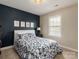 Cozy bedroom showcases navy blue accent wall, floral bedding, and natural light from the window at 875 Stratford Run Dr, Fort Mill, SC 29708