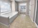 Bathroom boasts a jacuzzi tub, bright window, and a tiled floor, and is adjacent to another room at 9139 Hearst Ct, Charlotte, NC 28269