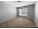 Bedroom has neutral walls and carpet, a bright window, and natural light at 9139 Hearst Ct, Charlotte, NC 28269