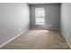This bedroom offers neutral walls and carpet, a bright window, and natural light at 9139 Hearst Ct, Charlotte, NC 28269
