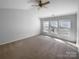 Bedroom boasts neutral walls and carpet, a ceiling fan, bright windows, and natural light at 9139 Hearst Ct, Charlotte, NC 28269