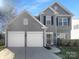 Traditional two-story home featuring gray siding, a two-car garage and manicured landscaping at 9139 Hearst Ct, Charlotte, NC 28269