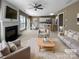 Bright open-plan living room featuring a fireplace, ceiling fan, and connection to kitchen at 9139 Hearst Ct, Charlotte, NC 28269