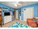 Bright blue bedroom with ceiling fan, a large dresser and school sports decor at 919 42Nd Avenue Ne Ln, Hickory, NC 28601
