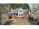 Charming two-story home with brick and white siding, black shutters, and mature trees in a landscaped yard at 919 42Nd Avenue Ne Ln, Hickory, NC 28601