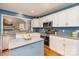 Well lit kitchen with white cabinets, stainless steel oven and microwave, blue walls, and an island with grey counters at 919 42Nd Avenue Ne Ln, Hickory, NC 28601