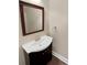 Classic powder room with a dark vanity, white sink, and framed mirror, perfect for guests at 9501 Brighthaven Ln, Charlotte, NC 28214