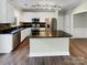 Modern kitchen with stainless appliances, a center island, and black countertops offering ample workspace at 9501 Brighthaven Ln, Charlotte, NC 28214