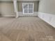 Spacious living room featuring carpet, wainscotting, and a large window for ample natural light at 9501 Brighthaven Ln, Charlotte, NC 28214