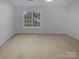 Sunlit room with neutral carpeting and a large window with a view of the backyard at 9930 Birch Knoll Ct, Charlotte, NC 28213