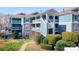 View of a multi-story condo building with blue siding, white balconies, and manicured landscaping at 1107 Torrence Cir, Davidson, NC 28036