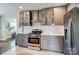 Modern kitchen with gray cabinets, stainless steel appliances, white countertops and white herringbone tile floors at 1700 Logie Ave, Charlotte, NC 28205