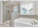Bright bathroom featuring a glass-enclosed shower, soaking tub, and tile surround at 2408 Napa Ter, Clover, SC 29710