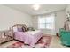 Cozy bedroom featuring a wicker headboard, pink quilt, area rug, and natural lighting at 2408 Napa Ter, Clover, SC 29710