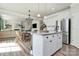 Modern kitchen featuring an island, stainless steel appliances, white cabinets, and an open view to living space at 2408 Napa Ter, Clover, SC 29710