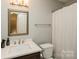 Well-lit bathroom featuring an updated vanity, mirror, toilet and shower at 6816 Charter Hills Rd, Charlotte, NC 28277
