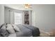 Cozy bedroom featuring large window, a ceiling fan, neutral decor, and a storage shelf at 6816 Charter Hills Rd, Charlotte, NC 28277