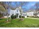 Charming two-story home featuring a well-manicured lawn, mature trees, and a classic white facade at 6816 Charter Hills Rd, Charlotte, NC 28277