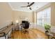 Stylish home office featuring hardwood floors, natural light from a large window, and a ceiling fan at 6816 Charter Hills Rd, Charlotte, NC 28277