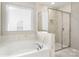 Bright bathroom featuring a soaking tub, glass-enclosed shower, and stylish marble tile at 838 Foxglove Ln, York, SC 29745
