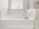 Bright bathroom featuring a soaking tub, window, and stylish marble tile at 838 Foxglove Ln, York, SC 29745