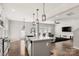 Open-concept kitchen with a central island, stainless steel sink, and modern light fixtures flowing into the living area at 838 Foxglove Ln, York, SC 29745