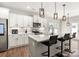 Modern kitchen with an island featuring barstool seating, stainless appliances, and white cabinetry at 838 Foxglove Ln, York, SC 29745