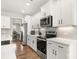 Close-up view of the kitchen featuring white cabinets, stainless steel appliances, and modern backsplash at 838 Foxglove Ln, York, SC 29745