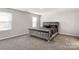 The main bedroom includes carpet floors, natural light, and a sizable gray velvet bed at 838 Foxglove Ln, York, SC 29745