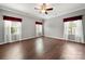 Large primary bedroom with hardwood floors, ceiling fan, and natural light from two windows at 10159 Lakeshore Dr, Lancaster, SC 29720