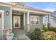Charming front porch with stone pillars, green siding, and a decorative storm door at 10159 Lakeshore Dr, Lancaster, SC 29720