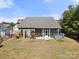 Back of home featuring an enclosed porch, hot tub, and well-maintained lawn with garden beds at 10159 Lakeshore Dr, Lancaster, SC 29720