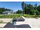 Beautiful backyard featuring stone patio with lounge chairs and lush, landscaped garden beds at 107 Hillside Cove Ct, Mooresville, NC 28117