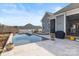 Backyard showcases an inviting pool, spa, grill, and elegant travertine patio at 107 Hillside Cove Ct, Mooresville, NC 28117