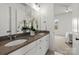 Primary bathroom featuring a double vanity with stone countertop, white cabinets, and a bedroom en suite at 107 Hillside Cove Ct, Mooresville, NC 28117