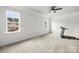 Spacious bedroom features neutral walls, plush carpeting, double windows, a ceiling fan, and gym equipment at 107 Hillside Cove Ct, Mooresville, NC 28117