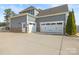 Home exterior with attached garages, stone accents, and professional landscaping at 107 Hillside Cove Ct, Mooresville, NC 28117