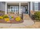 Inviting front porch with stone accents, black railing, and manicured landscaping at 107 Hillside Cove Ct, Mooresville, NC 28117