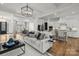 Inviting living room seamlessly connected to the kitchen, featuring a cozy sofa and stylish lighting fixtures at 107 Hillside Cove Ct, Mooresville, NC 28117