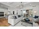 Sunlit living room features an open floorplan, stylish furniture, and sliding door access to screened in porch at 107 Hillside Cove Ct, Mooresville, NC 28117