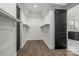 This walk-in closet features custom shelving, wood flooring, and black doors to provide contrast to the light room at 107 Hillside Cove Ct, Mooresville, NC 28117