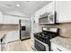 Modern kitchen featuring stainless steel appliances, white cabinets, granite countertops, and tile backsplash at 1121 Park West Dr, Charlotte, NC 28209