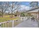 Spacious back porch with an outdoor dining set, offering a view of the expansive backyard and outbuildings at 117 Maple Hill Rd, Monroe, NC 28110