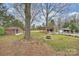 Large backyard featuring a fire pit, shed, and covered outdoor lounge area at 117 Maple Hill Rd, Monroe, NC 28110