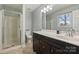 Bathroom with tiled floors, vanity with sink, toilet, and walk-in shower with glass enclosure at 117 Maple Hill Rd, Monroe, NC 28110
