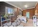 Bedroom with carpeted floor, wood paneled walls, two windows, and seating area with love seat at 117 Maple Hill Rd, Monroe, NC 28110