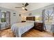 Bedroom with hardwood floors, ceiling fan, and two windows dressed with patterned curtains at 117 Maple Hill Rd, Monroe, NC 28110