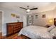 Bedroom featuring hardwood floors, ceiling fan, and two windows dressed with patterned curtains at 117 Maple Hill Rd, Monroe, NC 28110