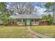 Charming brick home with a welcoming front porch and lush landscaping, enhanced by a pathway to the front door at 117 Maple Hill Rd, Monroe, NC 28110